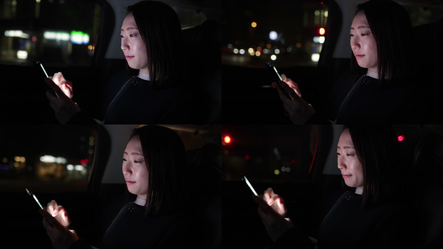 日本年轻女子夜间在出租车上使用智能手机