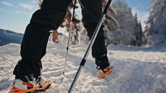阳光明媚的日子里，斯洛莫徒步旅行者和冰爪在雪地里散步