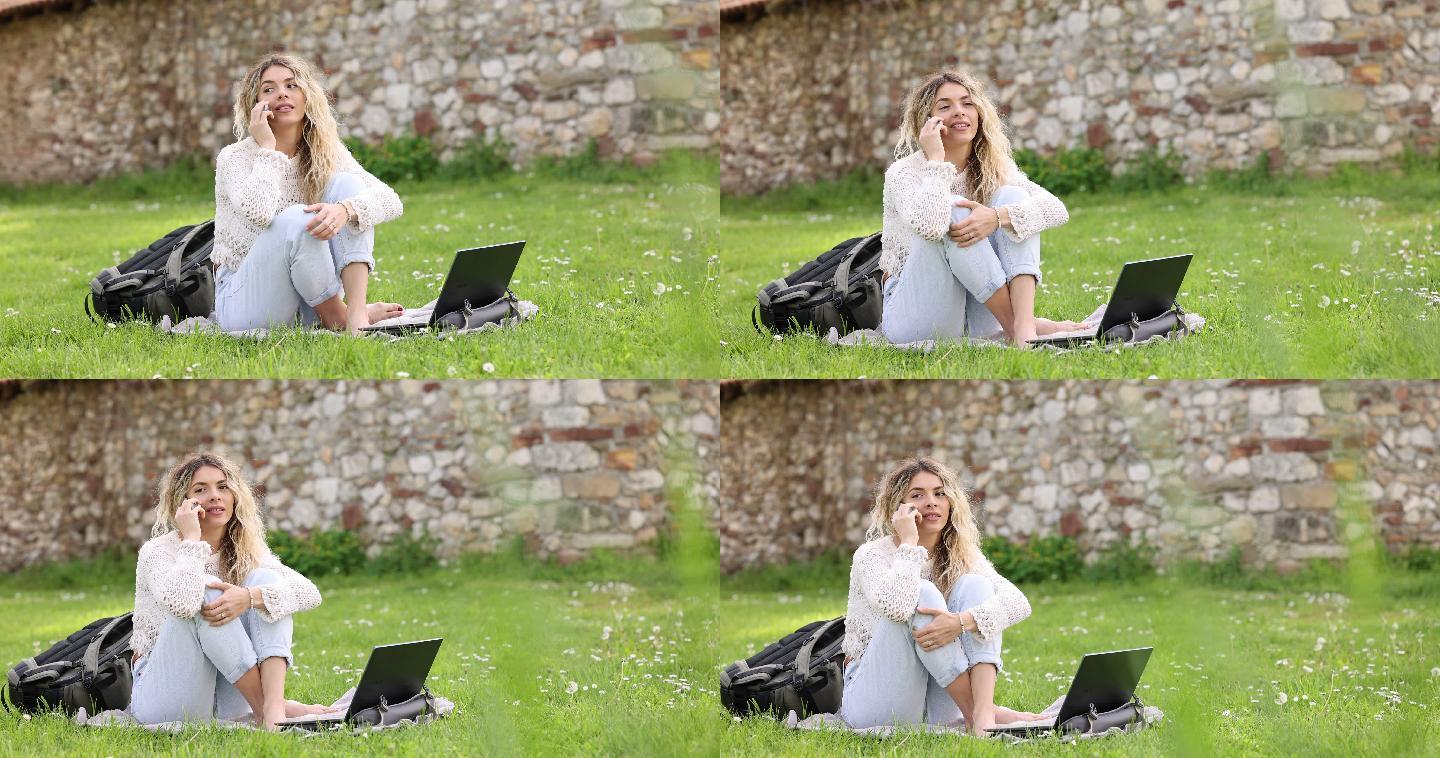 年轻的白人女性白天使用笔记本电脑和手机，背景是一个绿色公园