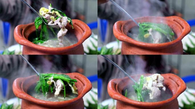 泰国火锅街头美食中的女孩手秀猪肉和蔬菜混合物（Jim Jum）