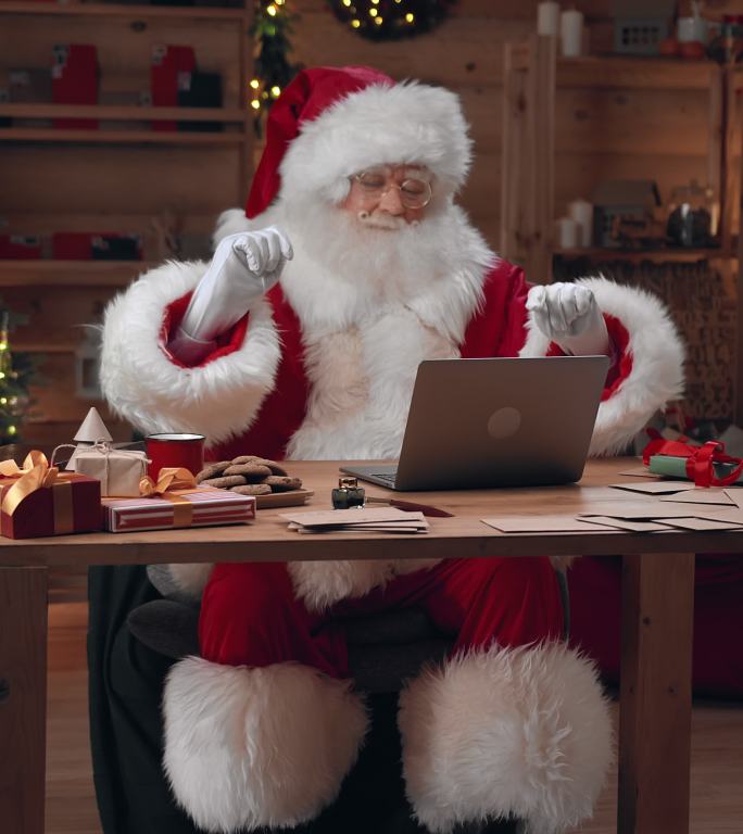 圣诞老人在笔记本电脑上完成了留言，躺在椅子上睡着了