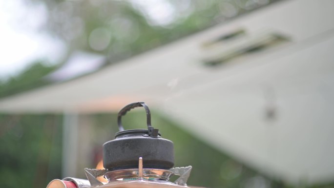 野营炉子早上在野餐桌上烧开的热水壶