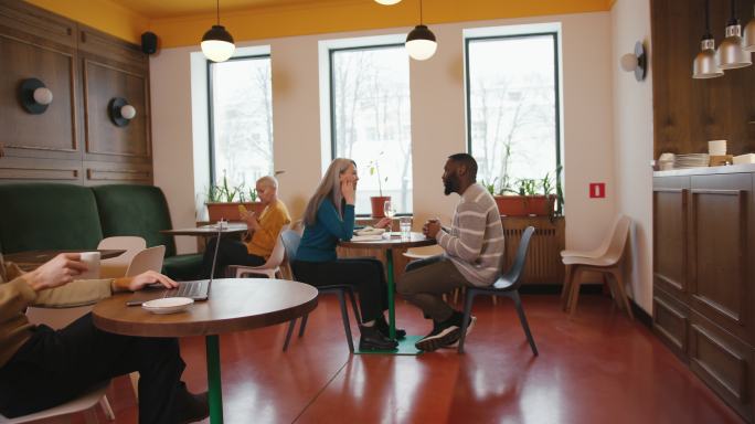 非裔美国男子和灰发女子在咖啡馆约会