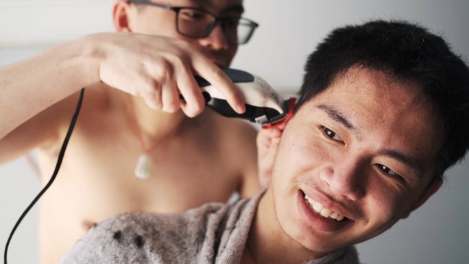 亚洲双胞胎青少年在家互相理发