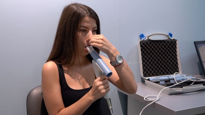 年轻女性患者在医生办公室进行肺功能测试和肺活量测定