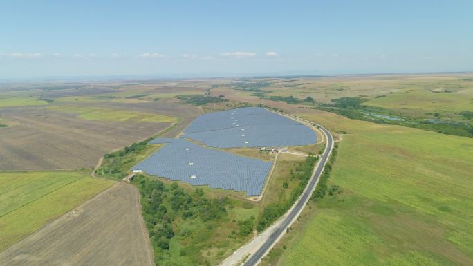 保加利亚农田之间的太阳能电池板田地。绿色/清洁能源、太阳能、可持续能源发电厂和可持续资源的概念，上升