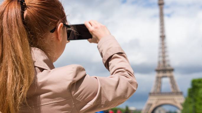 在Champ de Mars花园拍摄埃菲尔铁塔照片的女人