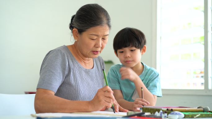 亚洲资深女子在家教孙子中国传统书法