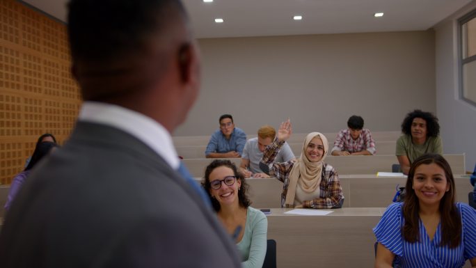 穆斯林大学生在课堂上举手向老师提问，大家都很高兴地集中注意力