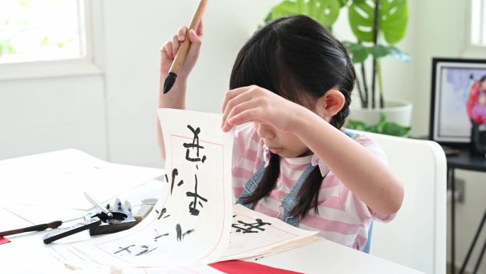 年轻的亚洲女孩在小学时学习中国书法