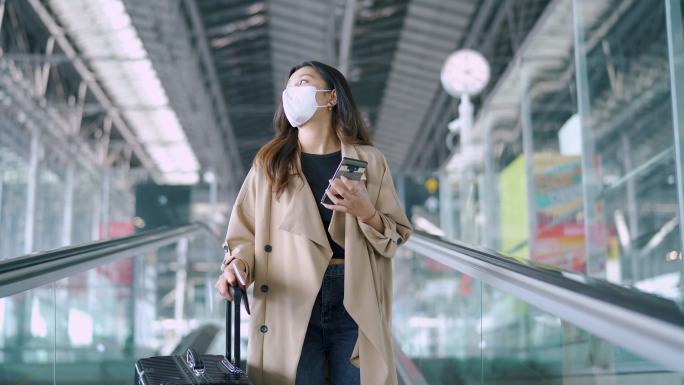 旅行者使用智能手机佩戴口罩。
