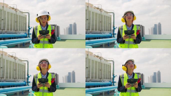 亚洲女性维护工程师检查大楼露台上的工作、大楼空调系统的维护