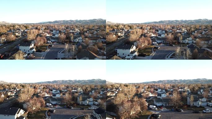 在一个晴朗的日子里，以山脉为背景，俯瞰郊区的独户住宅小区