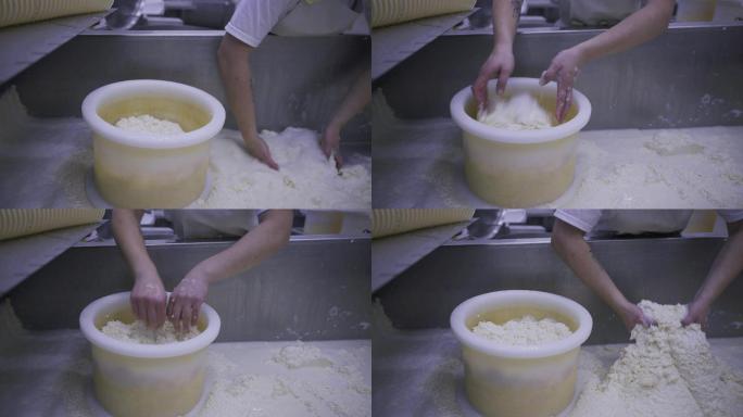 工人双手将奶酪凝乳放入桶中