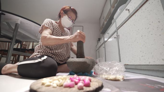 泰国妇女用石臼做辣椒酱
