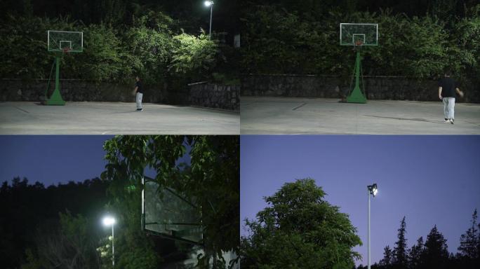 夜晚一个人在农村环境的篮球场上投篮上篮