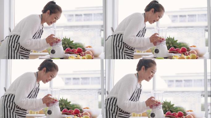 亚洲资深女性准备自制不同口味的水果冰沙，草莓、石榴、橘子和酸奶。健康天然益生菌风味饮料，侧视图