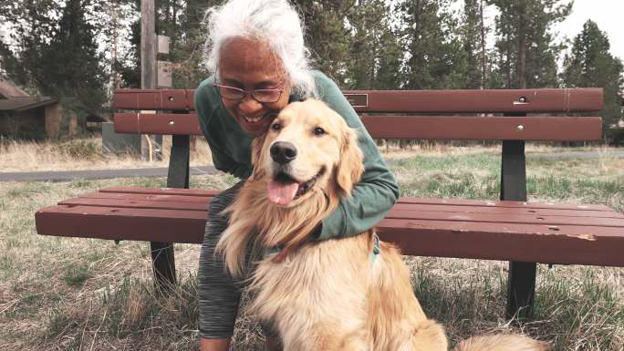 活跃的民族老年妇女和她的宠物狗一起享受户外活动