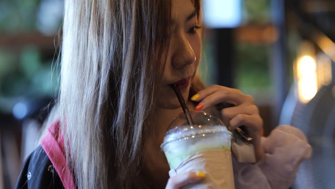 女性和冰镇绿茶亚洲女性正在快乐地喝绿茶。