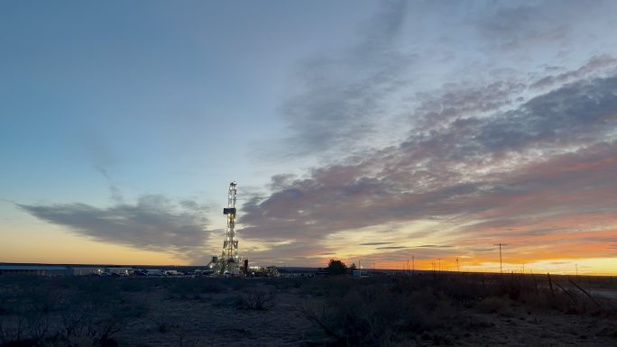 黎明或黄昏时分，在德克萨斯州西部或新墨西哥州东南部卡尔斯巴德附近的美国南部油田，延时压裂油气钻机