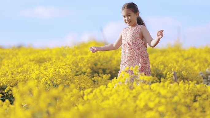 亚洲女孩在黄色花丛中奔跑