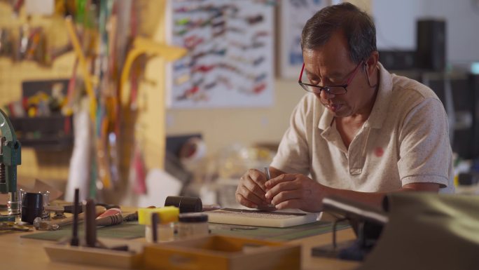 亚裔中国老人在工作室制作手工皮革表带