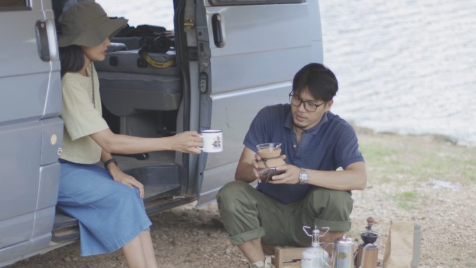 一对年轻夫妇在湖边露营时泡咖啡