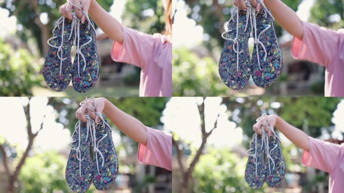 亚洲家庭主妇炫耀回收的环保拖鞋