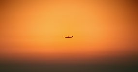 黄昏时分在橙色天空中飞过的飞机视频素材