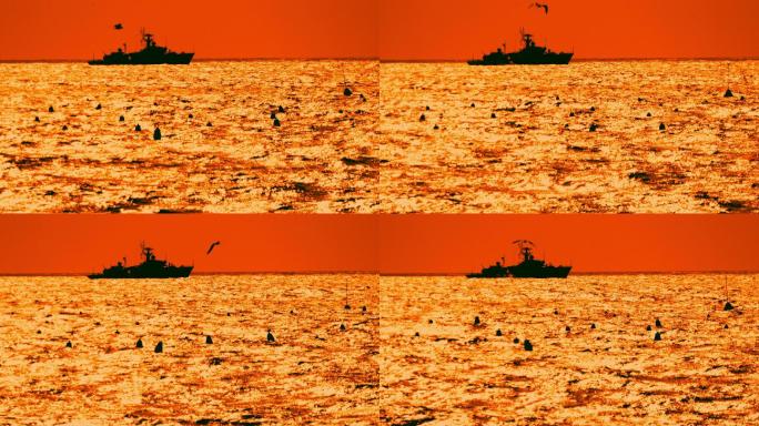 狂风暴雨的海上，一艘驱逐舰在日落时的剪影