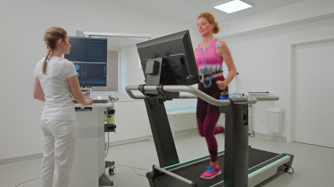 DS中年女性在跑步机上跑步并进行心脏压力测试