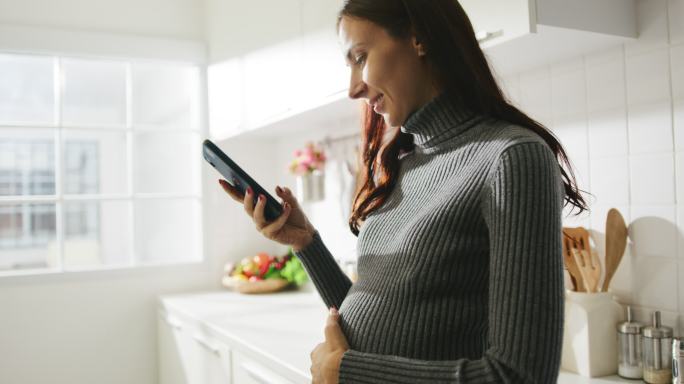 孕妇使用手机触摸孕肚玩手机休闲娱乐