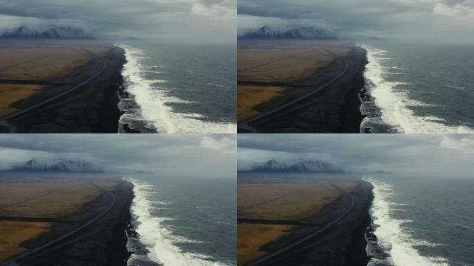 鸟瞰冰岛引人注目的黑色沙滩，沙滩上有冰山和山脉
