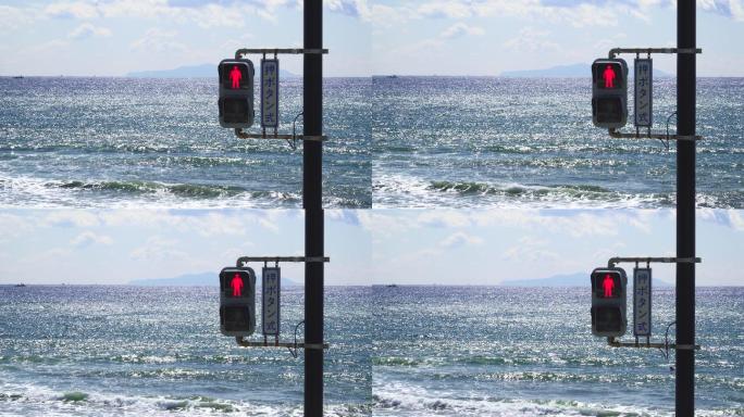 背景为大海的红绿灯。红色停止。