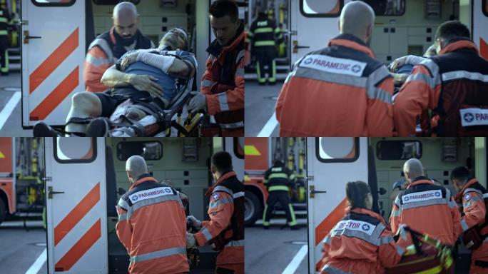 医护人员在事故现场将受伤的男性自行车手抬上救护车