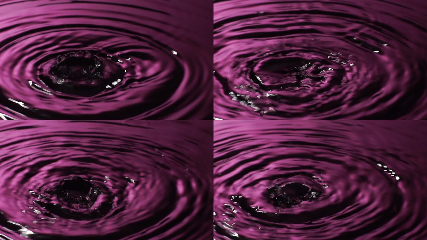 慢动作：许多水滴滴入粉红色的水中。