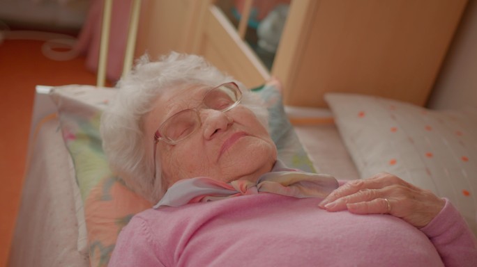 老年妇女在舒适的床上休息，睡得很好