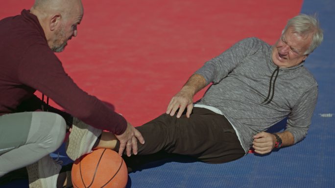 这位老人在与朋友的篮球比赛中膝盖受伤