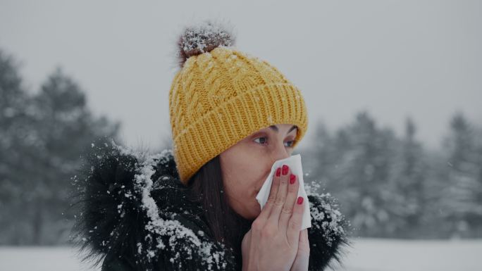 女人在擤鼻涕下雪天