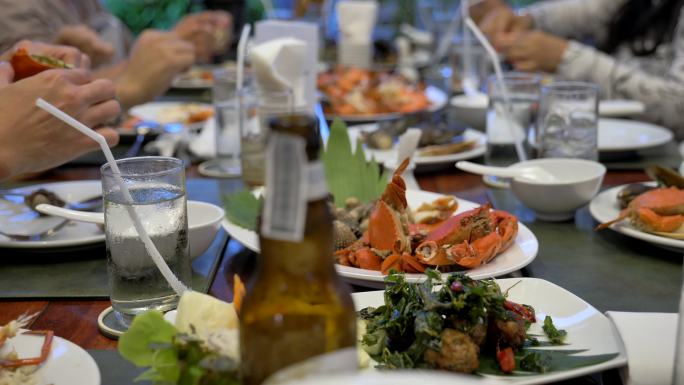 泰国海鲜的场景在餐厅的餐桌上，人们在餐厅用泰国菜用餐