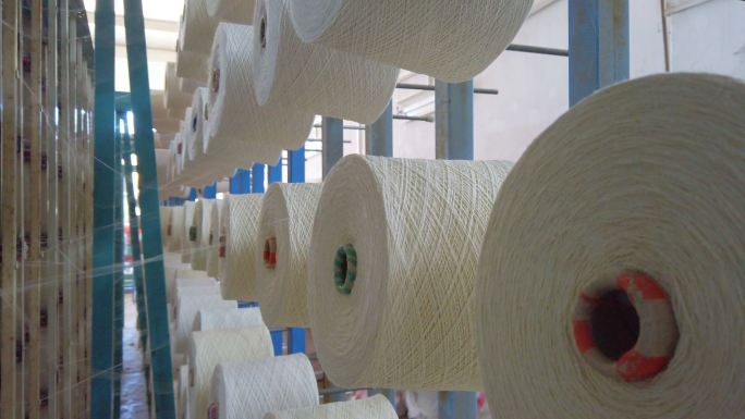 纺织厂工业整经针织束线机上的白纱卷轴筒管线锥按顺序排列