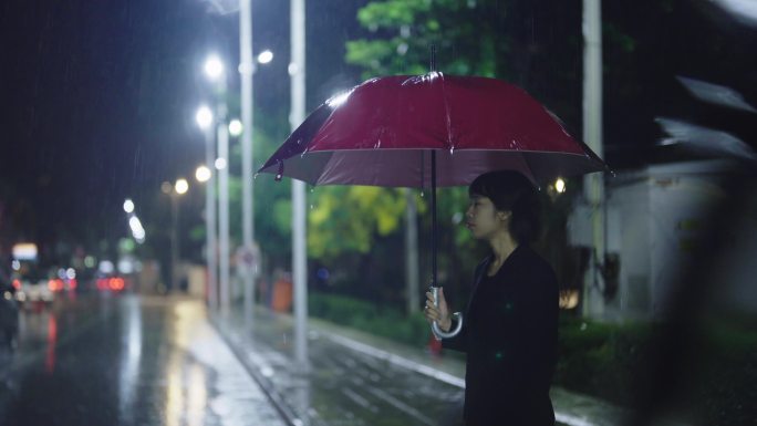 在雨中，一位亚洲妇女撑着雨伞。