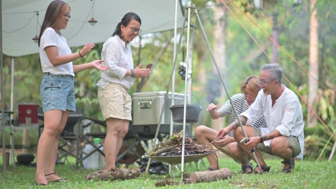 一个亚裔中国家庭，有两个成年子女，正在生火，准备做饭