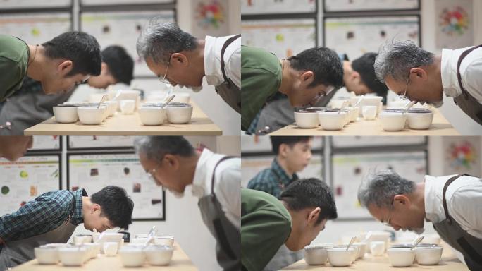专业亚裔中国男咖啡师品级师在咖啡杯上弯腰，仔细闻每一杯咖啡