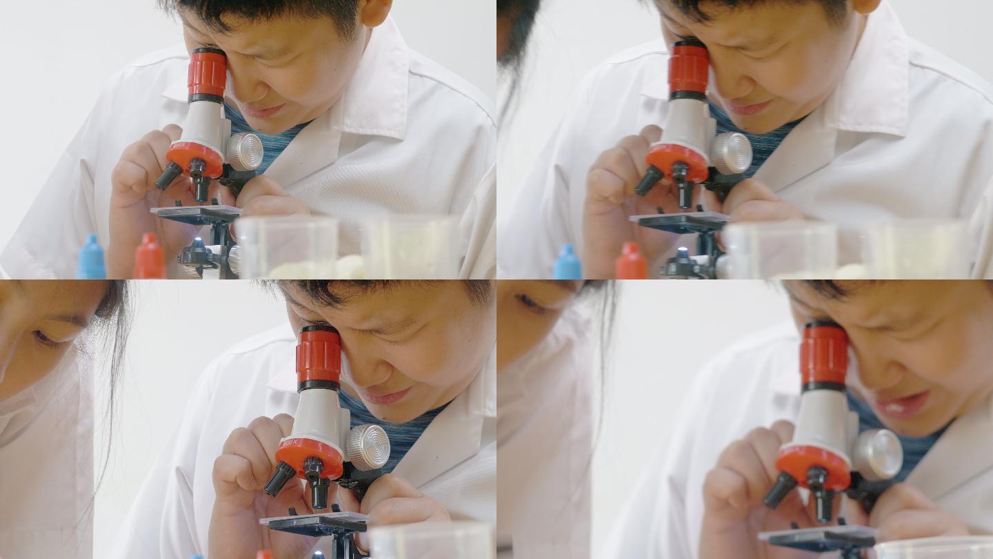 亚洲孩子在实验室里用显微镜进行科学实验，在家里的实验室里，教育他们的生活方式理念。