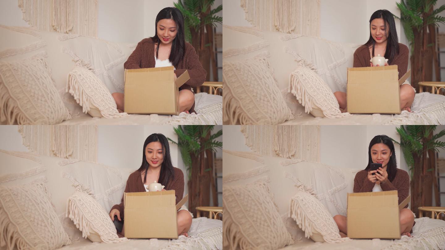 快乐的亚裔中国女子在客厅收到网上购物的破茶壶