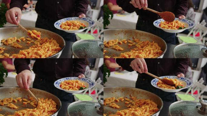 一名男子在自助午餐中为自己端上意大利面食的特写镜头