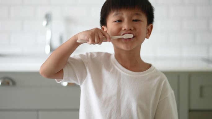 亚洲小孩在浴室刷牙。日常健康和牙科护理的概念