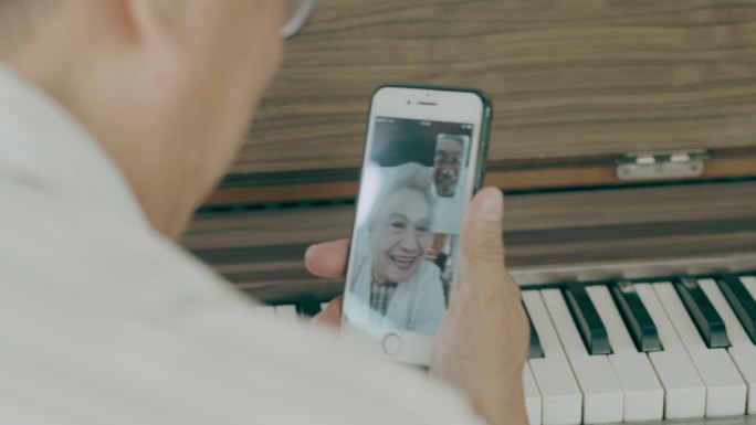泰国祖父在祖母家中使用智能手机时与祖母交谈，怀着爱与思念