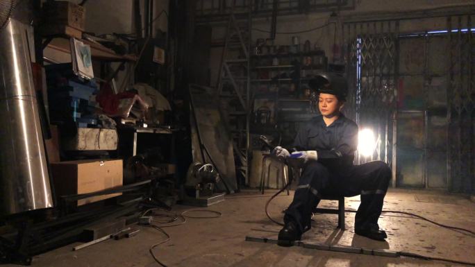 亚裔中国女焊工在车间使用焊枪